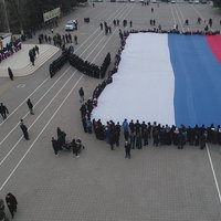 Флаг с российским триколором рекордного размера развернули в Каспийске в поддержку российских солдат.